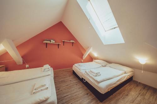 a attic bedroom with a bed and a skylight at Hotel Hospodářský dvůr Bohuslavice in Telč