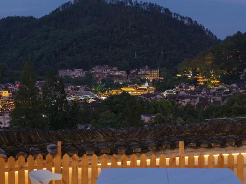 a view of a city with a fence and a mountain at 云起山居庭院观景民宿 in Fenghuang
