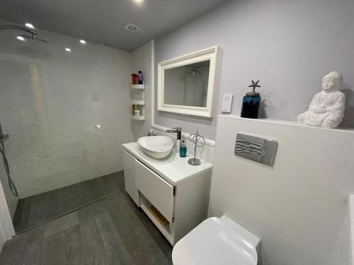 a white bathroom with a sink and a toilet at Aphrodite Beachfront Resort Official in Ghaziveran