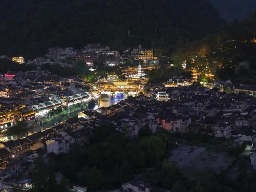 a view of a city at night with lights at 云起山居庭院观景民宿 in Fenghuang