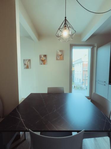 a dining room with a black table and chairs at Fiore di Langa - Residence in Monforte d'Alba in Monforte dʼAlba
