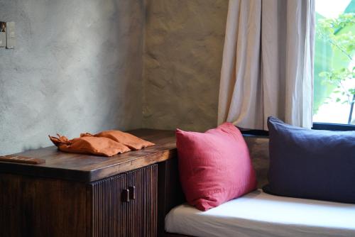 a wooden table with two pillows next to a couch at Dechiu in Hoi An