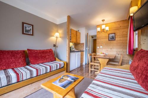 un salon avec un canapé et une table dans l'établissement Résidence Pierre & Vacances Les Sentiers du Tueda, à Méribel