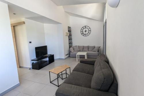 un salon avec un canapé et une télévision dans l'établissement Charming Apartment in La Rochelle for 4p, à La Rochelle