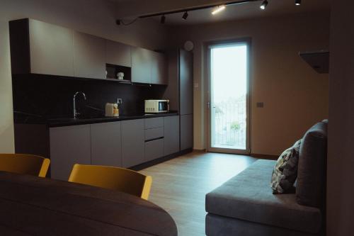 a kitchen with a couch and a table and a window at Fiore di Langa - Residence in Monforte d'Alba in Monforte dʼAlba