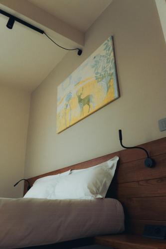 a bedroom with a bed and a painting on the wall at Fiore di Langa - Residence in Monforte d'Alba in Monforte dʼAlba