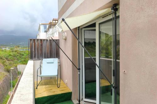 a balcony with a blue chair on the side of a building at Nice T2 with Wifi - balcony and view in Sarrola-Carcopino