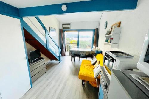 a living room with a yellow couch and a table at Beautiful apartment at 100m from the beach in Calcatoggio