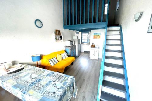 Cette chambre dispose d'un escalier et d'un canapé jaune. dans l'établissement Beautiful apartment at 100m from the beach, à Calcatoggio