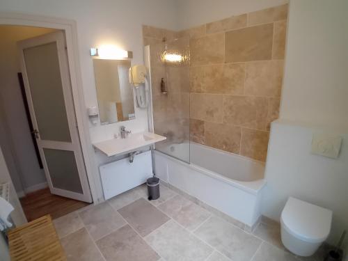 a bathroom with a sink and a tub and a toilet at Grand Hôtel de l'Europe - Morlaix Centre in Morlaix