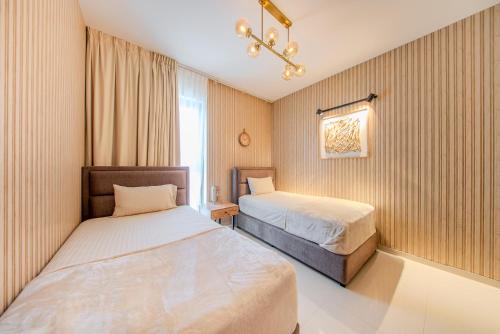 a hotel room with two beds and a window at 2BR Luxury Apartment in Al Zahia Pool View by BlueCloud holidays in Sharjah