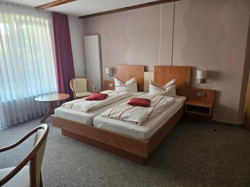 a hotel room with two beds with red pillows at Hotel zur Krone in Hasselfelde