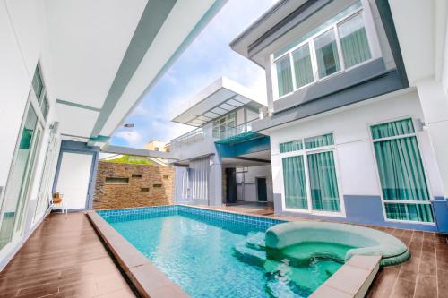 a swimming pool in front of a house at Luxury Pure Modern Pool Villa 5Bed KTV Gym Nr BTS&Central in Bangkok
