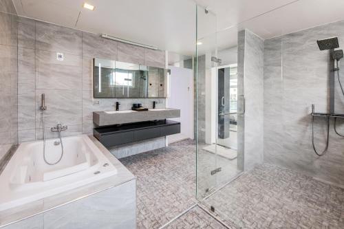 a bathroom with a tub and a sink and a shower at Luxury Pure Modern Pool Villa 5Bed KTV Gym Nr BTS&Central in Bangkok
