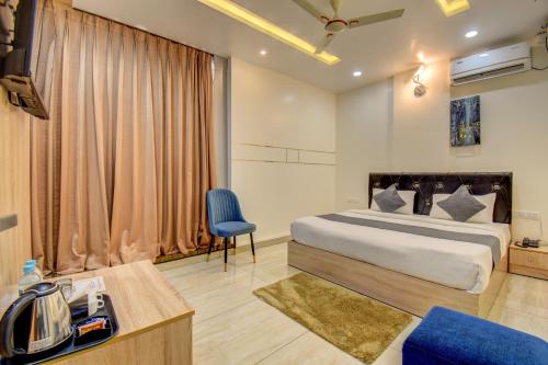 a hotel room with a bed and a chair at Le Mysuru Palace in Mysore