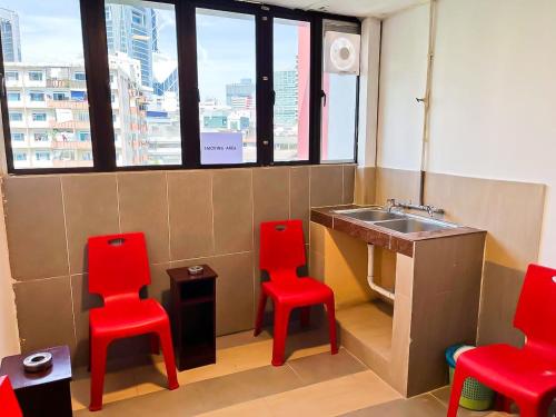 a bathroom with two red chairs and a sink at J Hotel Masjid India KL in Kuala Lumpur