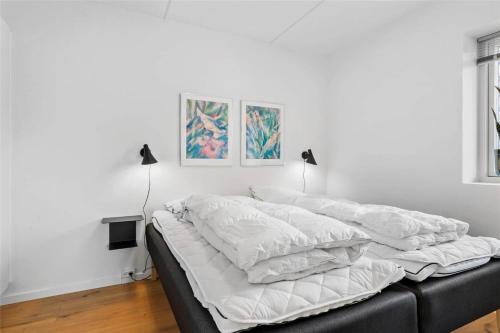 a bedroom with a bed with white sheets and two lamps at 785-Thisted-Havstokken-32-A in Thisted