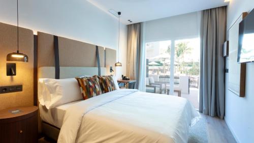 a hotel room with a bed and a balcony at Hotel Indigo Gandia Beach by IHG in Gandía