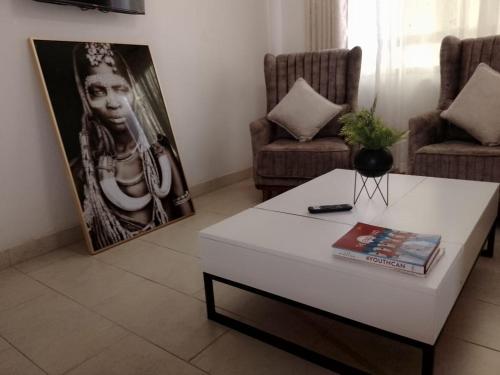 a living room with a coffee table and a picture of a woman at THE LAGOON RESORT AND Spa in Kutu
