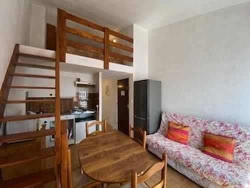 - un salon avec une table et des lits superposés dans l'établissement Port-la-Nouvelle: T2 Mezzanine, Terrasse, Parking, à 300m de la Plage! - FR-1-229C-85, à Port-la-Nouvelle