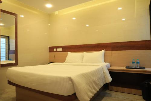 a bedroom with a large bed and a mirror at TCS Residency in Kanchipuram