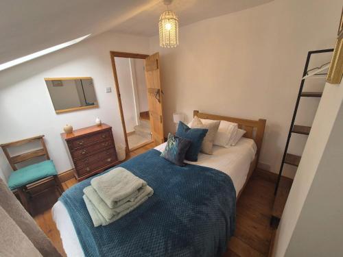 a bedroom with a bed and a dresser and a mirror at Lime Kiln Quay Cottage in Woodbridge