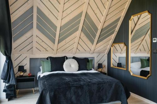 a bedroom with a large bed with a wooden ceiling at Osada Maruszyna in Szaflary