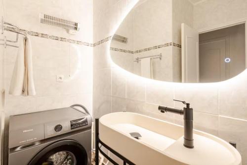 a bathroom with a sink and a washing machine at Maison Lydia, Climatisation, BBQ & Plage 2 min à pied in Le Barcarès