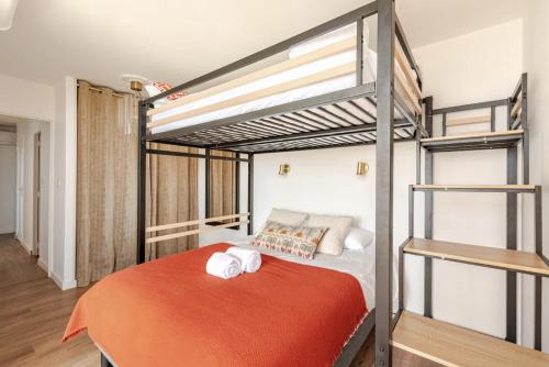 a bedroom with a bunk bed with a orange bedspread at Maison Lydia, Climatisation, BBQ & Plage 2 min à pied in Le Barcarès