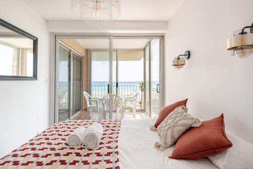 a bedroom with a bed with a view of the ocean at Maison Lydia, Climatisation, BBQ & Plage 2 min à pied in Le Barcarès