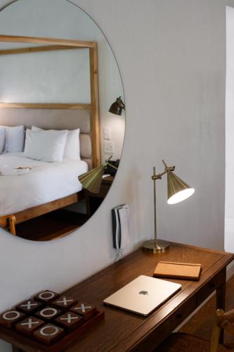 a bedroom with a bed and a desk with a mirror at La Paris Estate in Franschhoek