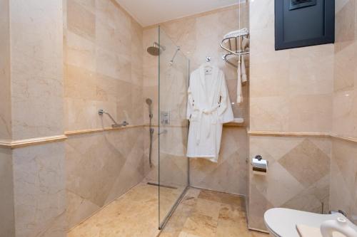 a bathroom with a shower with a white robe hanging on the wall at Istanbul Apartments in Istanbul