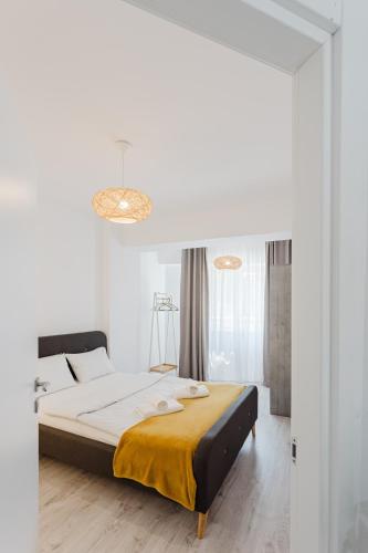 a bedroom with a large bed with a yellow blanket at City Center Accommodation 103 in Reşiţa