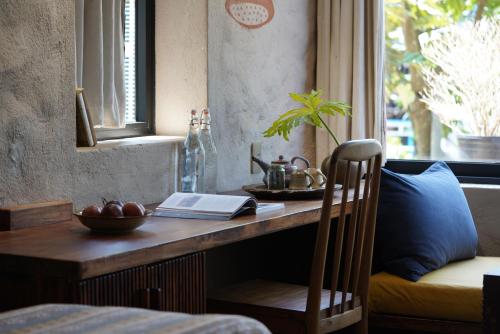 a wooden table with a book on it next to a window at Dechiu in Hoi An