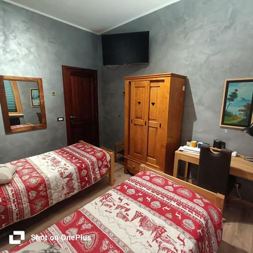 a bedroom with two beds and a cabinet and a desk at La Cerasa in Contigliano