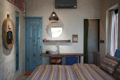 a bedroom with a bed and a sink and a mirror at Dechiu in Hoi An