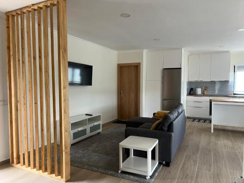 a living room with a couch and a kitchen at Casa da Mini in Mondim de Basto