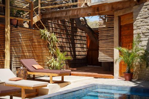 a patio with a pool and a chair next to a building at Eco Lodge Mancora in Máncora