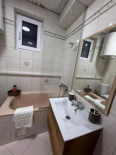 a bathroom with a sink and a tub and a mirror at Villa Georgi in Ohrid