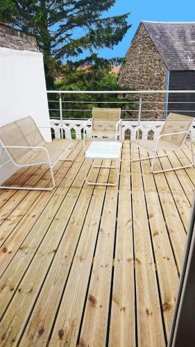 a deck with two chairs and two chairs on it at 35 m2 charmant plus 30 M2 de terrasse Accès jardin SPA in Boulogne-sur-Mer