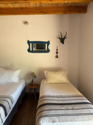a bedroom with two beds and a mirror on the wall at Casa Luna in San Pedro de Atacama