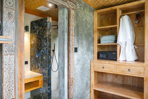 a bathroom with a shower and a wooden cabinet at Lorel Green Domain Ubud in Ubud