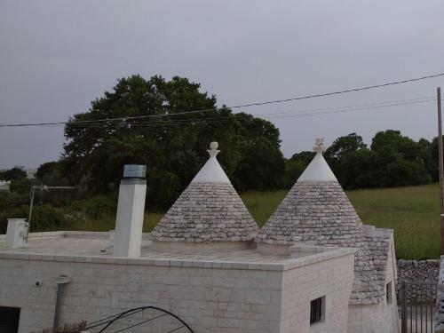 a building with three pointed towers on top of it at Trullo Le Tre Sorelle in Cisternino