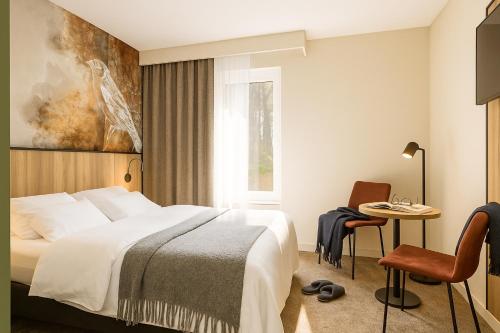 a hotel room with a bed and a table at Fletcher Hotel-Restaurant De Kempen in Reusel