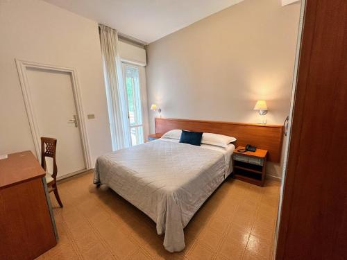 a bedroom with a bed and a table and a window at Aura Living Hotel in Rimini