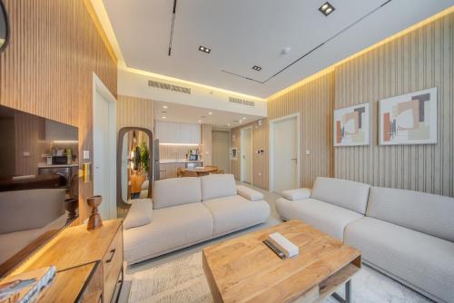 a living room with a white couch and a table at 2BR Aljada Apartment - 3 Washrooms - Sleeps 6 - Boulevard in Sharjah