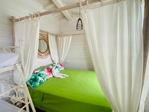 a bedroom with a green bed with a curtain at Villa Poggio Ulivo Pool-Apartments in Rivoli Veronese