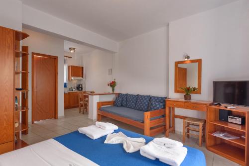 a bedroom with a blue bed and a blue couch at Finikas Studios & Apartments - Kalamaki Holidays in Kalamaki