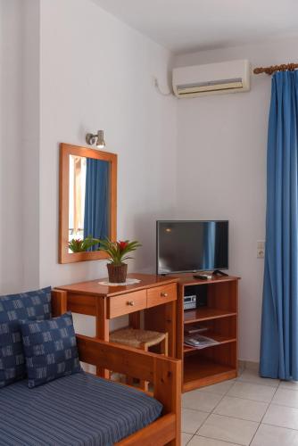 a living room with a couch and a tv at Finikas Studios & Apartments - Kalamaki Holidays in Kalamaki