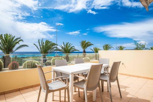 a table and chairs on a balcony with a view of the ocean at Casa das Pedras Pretas - By WeHost in Porto Santo